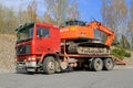 Red Volvo F12 Intercooler Hauls a Hitachi Zaxis Excavator Royalty Free Stock Photo